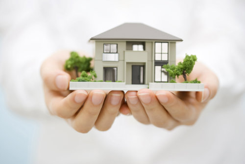 woman hands holding a a hand-made house model