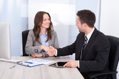 consultant and client shaking their hands as a symbol of agreement